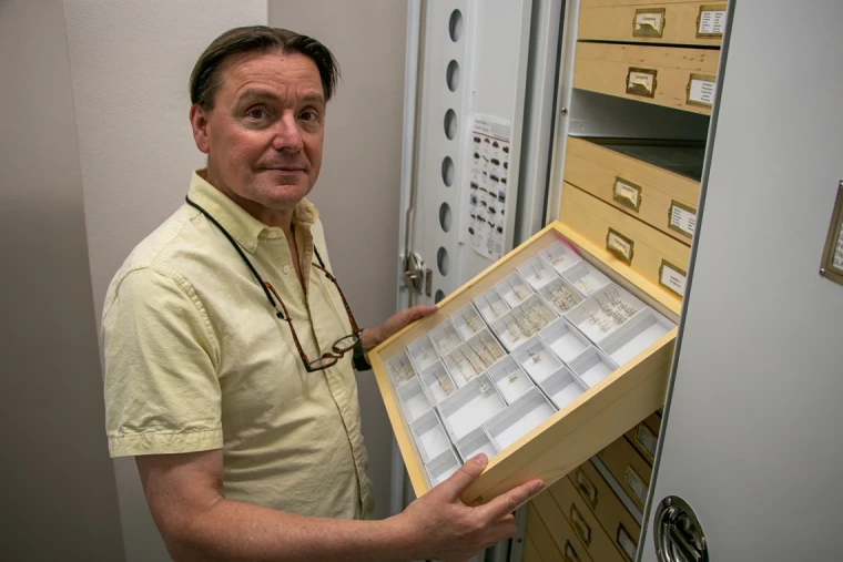 Gene Hall holds specimen collection in the UAIC